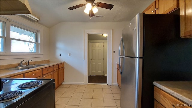 kitchen with stainless steel fridge, ceiling fan, sink, light tile patterned floors, and black range with electric stovetop