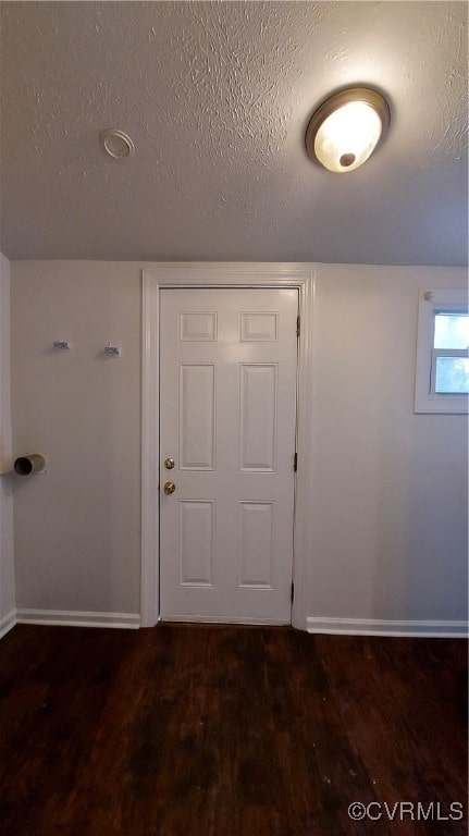 doorway featuring a textured ceiling and dark wood-type flooring