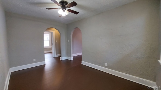 spare room with dark hardwood / wood-style floors and ceiling fan