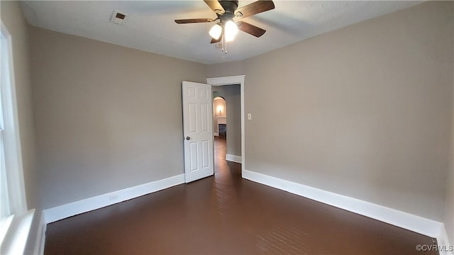 unfurnished room featuring ceiling fan and dark wood-type flooring