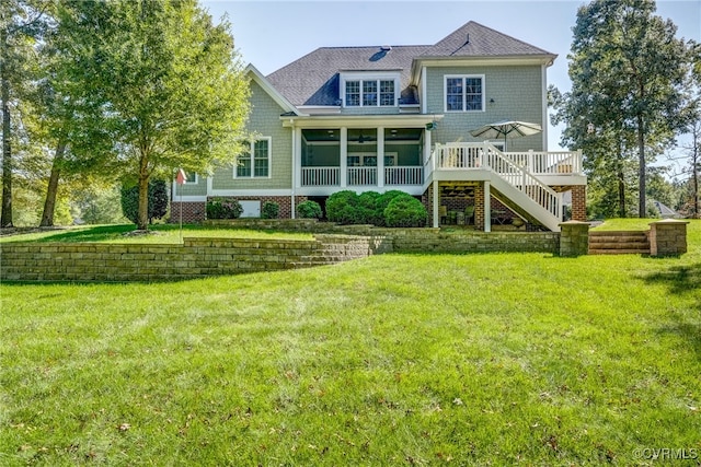 back of property featuring a yard, a sunroom, and a deck