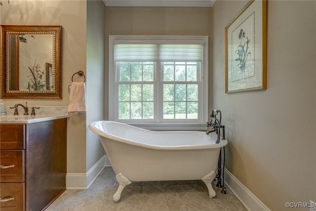 bathroom with tile patterned floors, crown molding, a washtub, and vanity