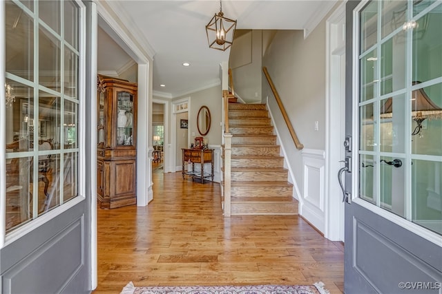 foyer featuring crown molding and light hardwood / wood-style flooring