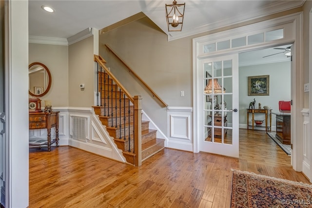 foyer entrance with hardwood / wood-style flooring and ornamental molding