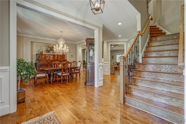 interior space with a chandelier, crown molding, and light hardwood / wood-style flooring