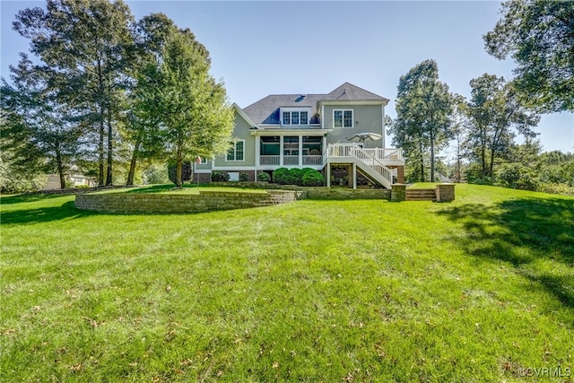 rear view of property with a deck and a lawn