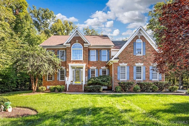 colonial-style house featuring a front yard