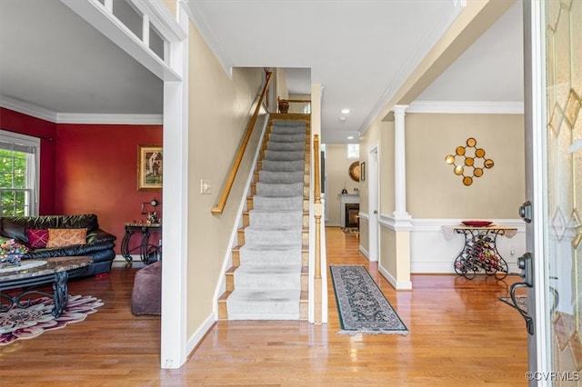 stairs featuring hardwood / wood-style flooring and crown molding