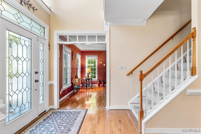 entryway with light hardwood / wood-style flooring and crown molding