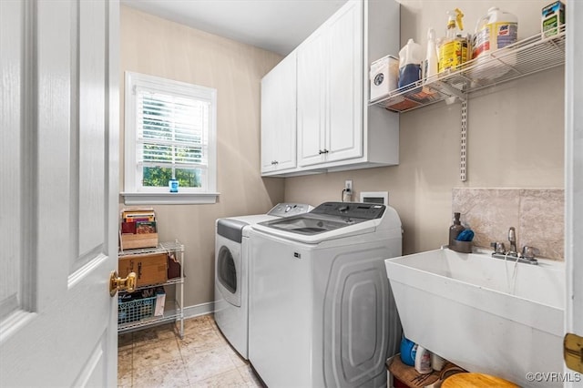 clothes washing area featuring cabinets, separate washer and dryer, and sink