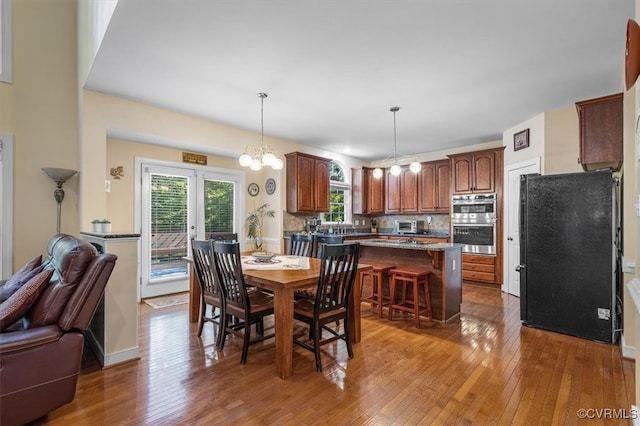 dining room with french doors, hardwood / wood-style flooring, and a notable chandelier