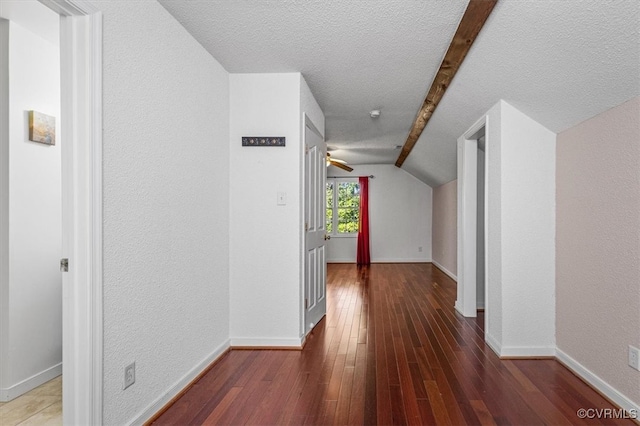 hallway featuring hardwood / wood-style floors, lofted ceiling with beams, and a textured ceiling