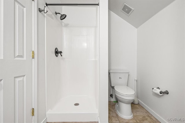 bathroom featuring tile patterned floors, toilet, lofted ceiling, and walk in shower