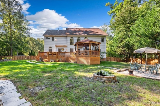 rear view of house with a gazebo, a yard, and a wooden deck