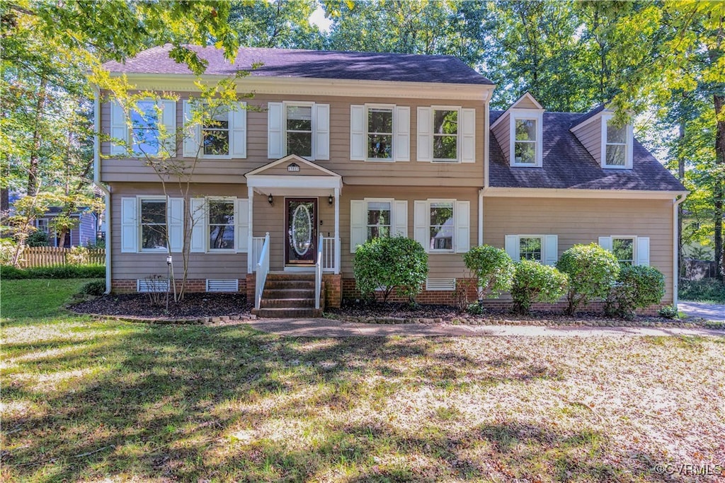 colonial inspired home with a front lawn