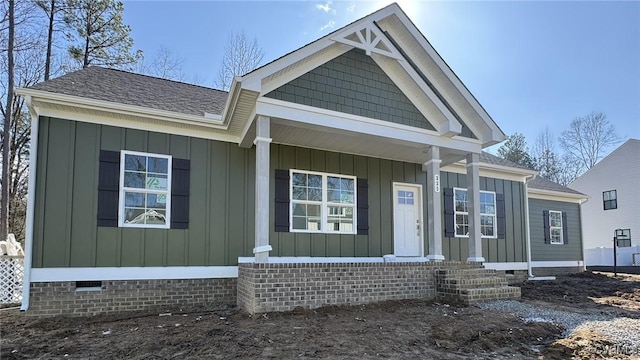 view of front of house featuring crawl space, covered porch, a shingled roof, and board and batten siding