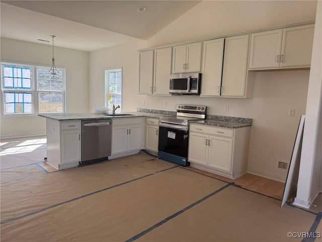 kitchen featuring pendant lighting, stainless steel appliances, white cabinetry, a sink, and a peninsula