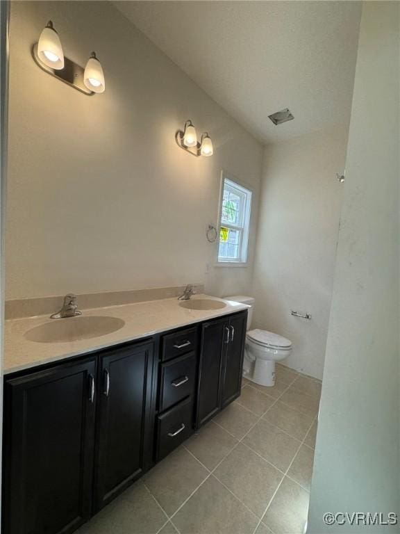 full bath with tile patterned floors, a sink, toilet, and double vanity