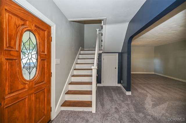 foyer entrance featuring carpet floors and vaulted ceiling