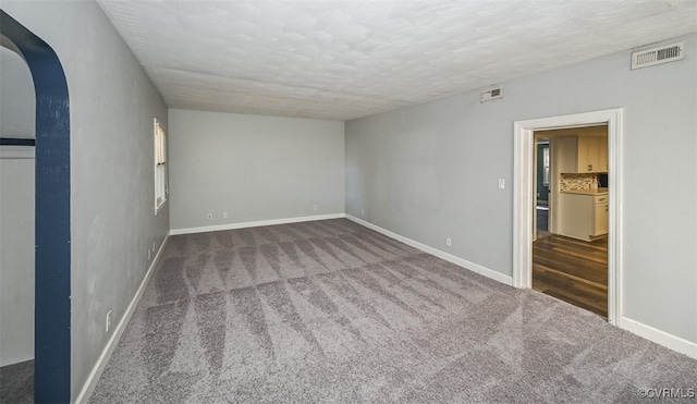 carpeted spare room with a textured ceiling