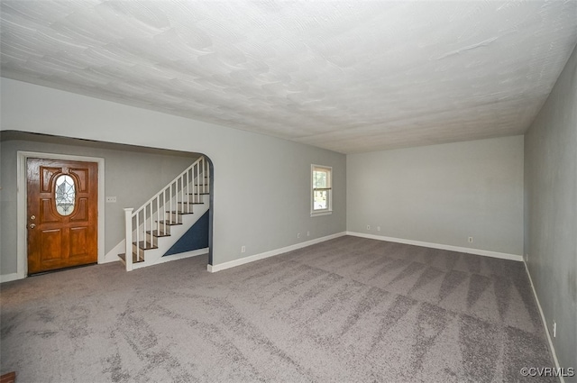 unfurnished living room with carpet floors and a textured ceiling