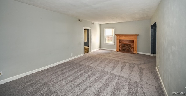 unfurnished living room featuring a brick fireplace and carpet flooring