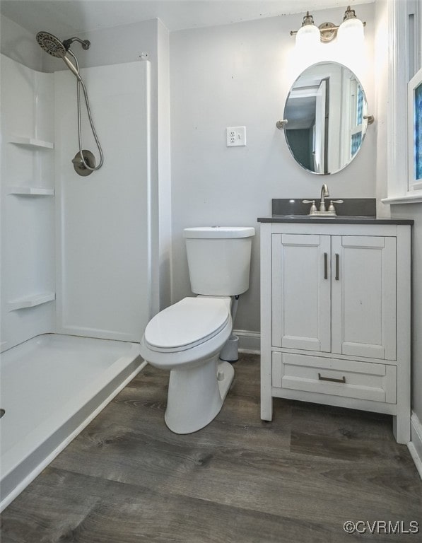 bathroom featuring vanity, a shower, toilet, and hardwood / wood-style flooring