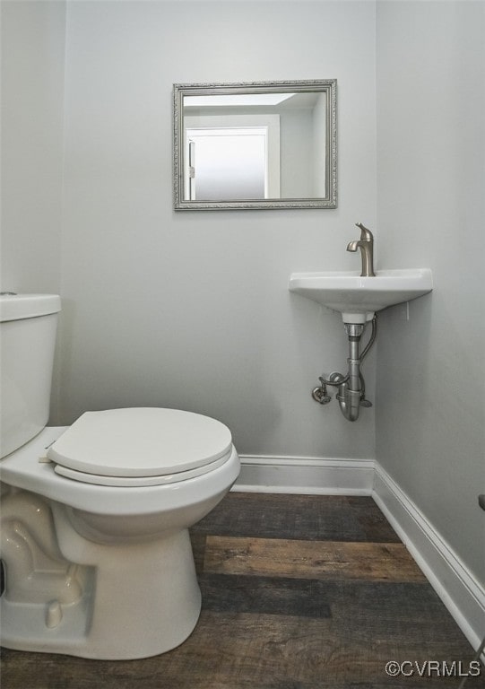 bathroom featuring wood-type flooring and toilet