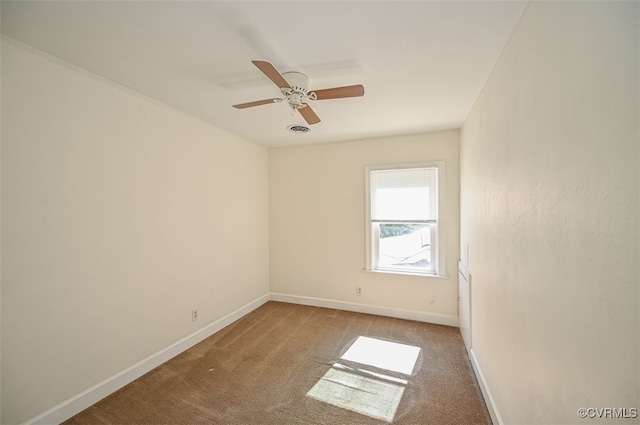 carpeted spare room featuring ceiling fan