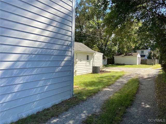 view of yard featuring cooling unit and a storage unit