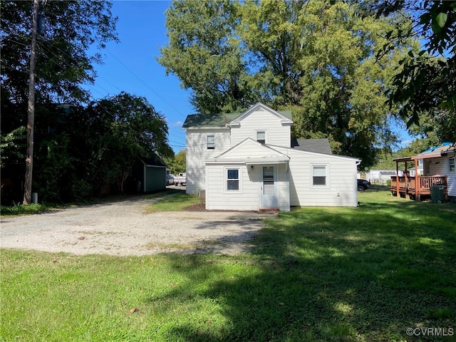 back of property featuring a lawn and a deck