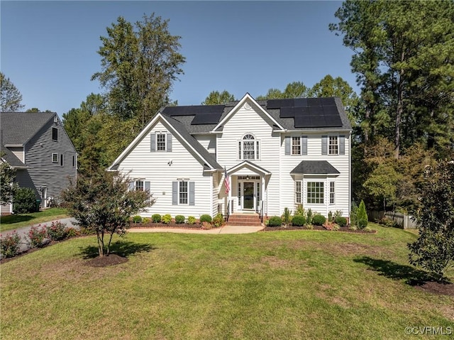 view of front of house with a front yard and solar panels