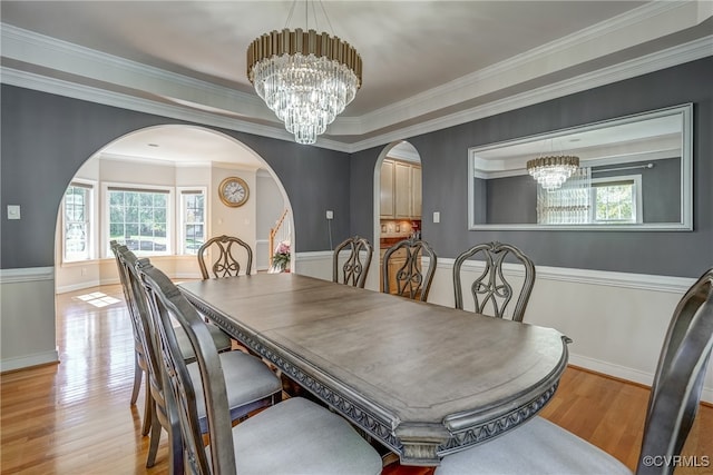 dining space with a chandelier, light hardwood / wood-style floors, and crown molding