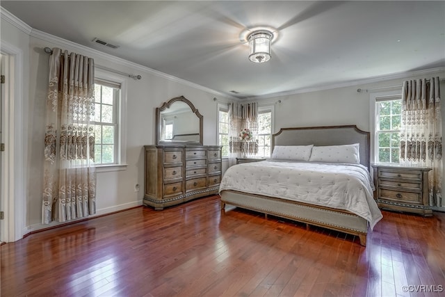 bedroom featuring hardwood / wood-style flooring, ornamental molding, and multiple windows