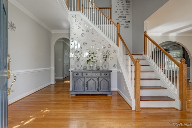 staircase featuring wood-type flooring and crown molding