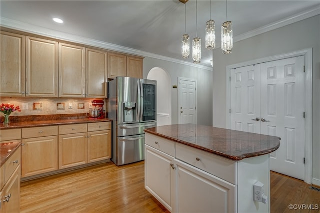 kitchen with decorative backsplash, ornamental molding, light hardwood / wood-style flooring, stainless steel fridge with ice dispenser, and a center island