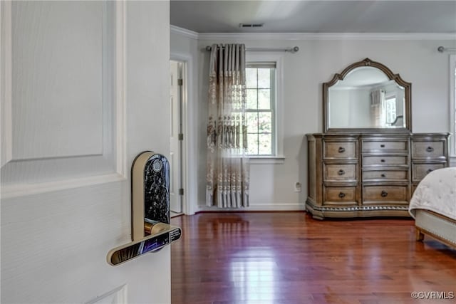 bedroom with dark hardwood / wood-style flooring and ornamental molding