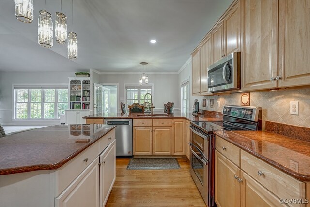 kitchen featuring plenty of natural light, sink, stainless steel appliances, and an inviting chandelier