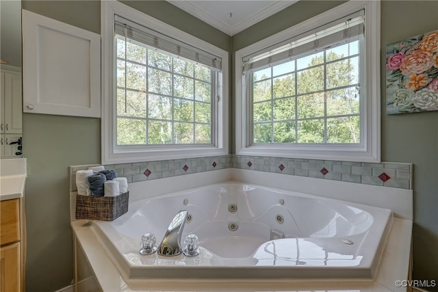 bathroom featuring ornamental molding, vanity, tiled bath, and a healthy amount of sunlight