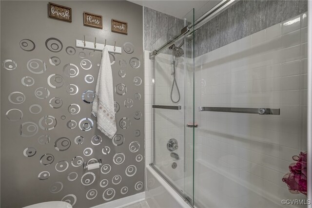 bathroom with bath / shower combo with glass door