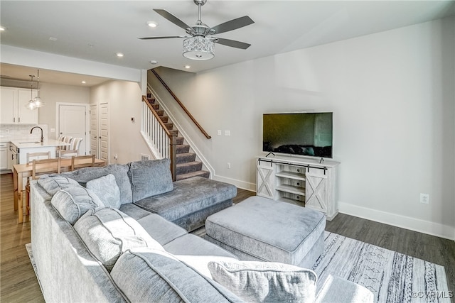 living room with dark hardwood / wood-style floors, sink, and ceiling fan