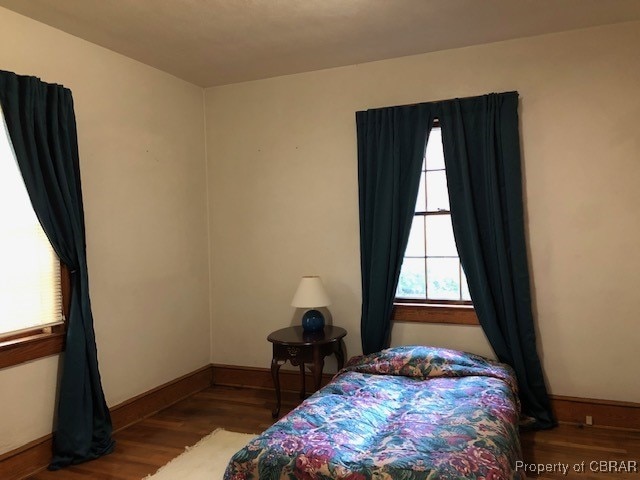 bedroom with dark wood-type flooring