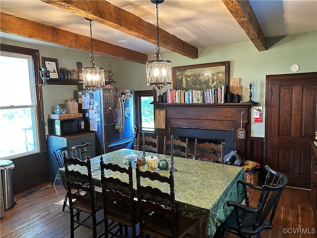 dining room with beamed ceiling, dark hardwood / wood-style floors, and a wealth of natural light