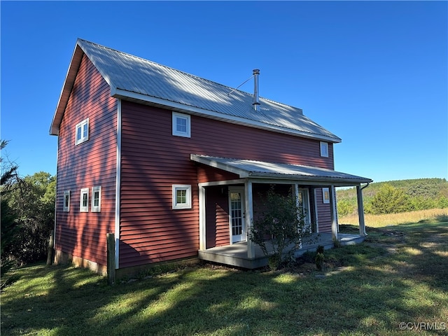 rear view of house featuring a yard