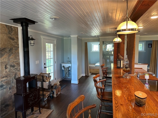 dining space with a wood stove, sink, dark hardwood / wood-style flooring, and a healthy amount of sunlight