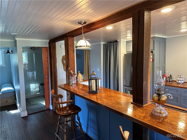 bar featuring pendant lighting, ornamental molding, dark hardwood / wood-style flooring, and butcher block counters