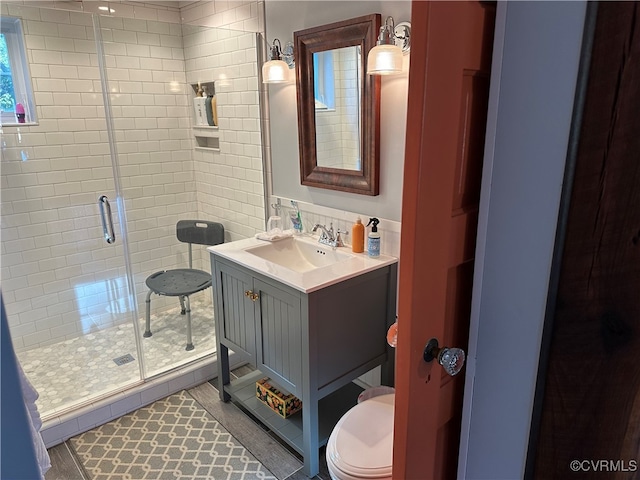 bathroom featuring an enclosed shower, toilet, and vanity