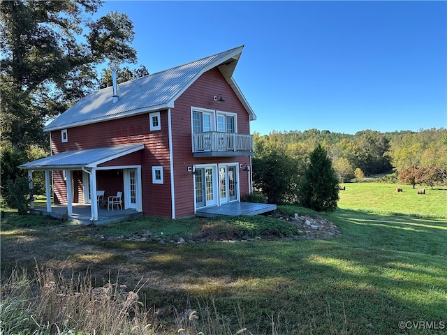 back of property with french doors, a patio, and a lawn