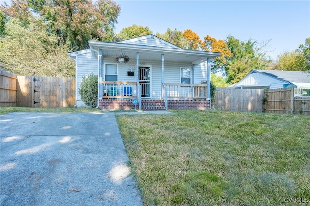 bungalow-style house with a front lawn and covered porch