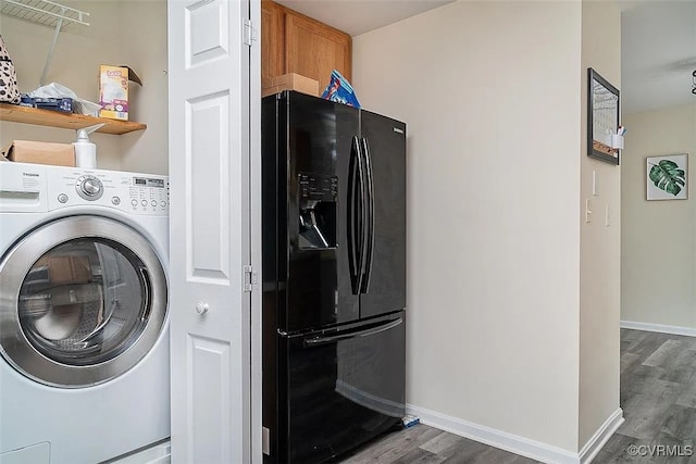 laundry room with dark wood-type flooring and washer / dryer